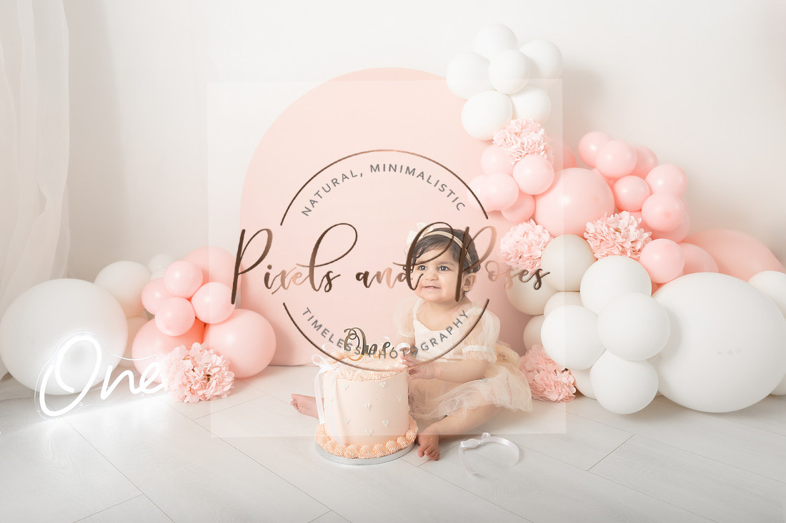 Pastel pink balloon arch cake smash first birthday photoshoot in Derbyshire studio